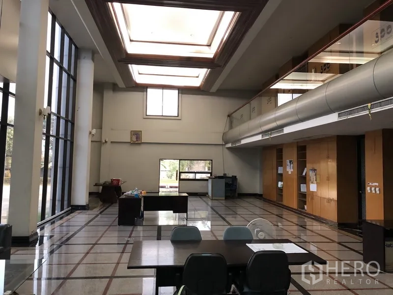 Factory for rent in Bang Bua Thong, Nonthaburi - Double‑height office area with floor‑to‑ceiling windows and skylights.
