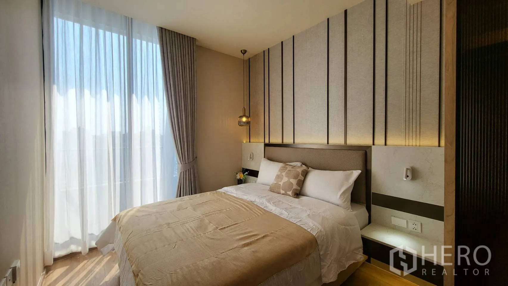 คอนโด for sale in Watthana, Bangkok - ห้องนอนที่สองมีผนังตกแต่ง ไฟแขวน หน้าต่างบานใหญ่พร้อมม่านโปร่ง และชุดเครื่องนอนนุ่ม
