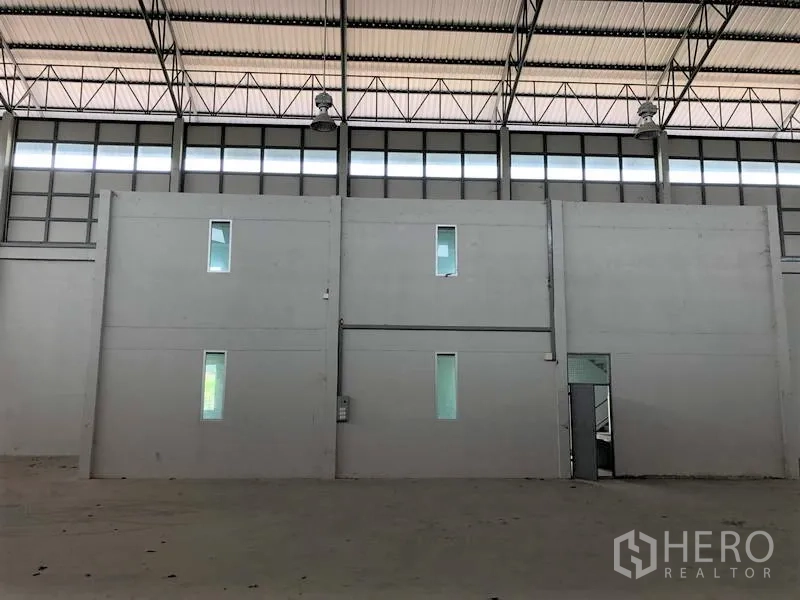 Factory for rent in Lam Luk Ka, Pathum Thani - Two‑storey internal office block inside the warehouse with narrow windows and high clerestory glazing.