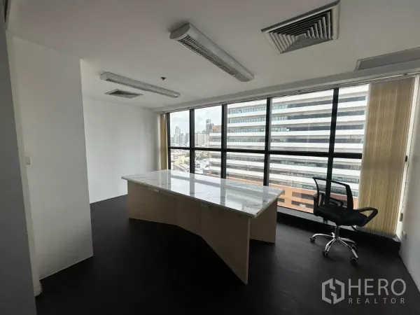 Office Space for rent in Watthana, Bangkok - Private corner office with marble-top desk and floor-to-ceiling windows overlooking the skyline.