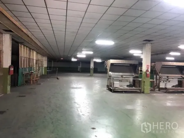 工厂 出租在Lat Krabang, Bangkok - 宽敞生产车间，柱网布局，天花灯明亮并配有工业设备，混凝土地面。