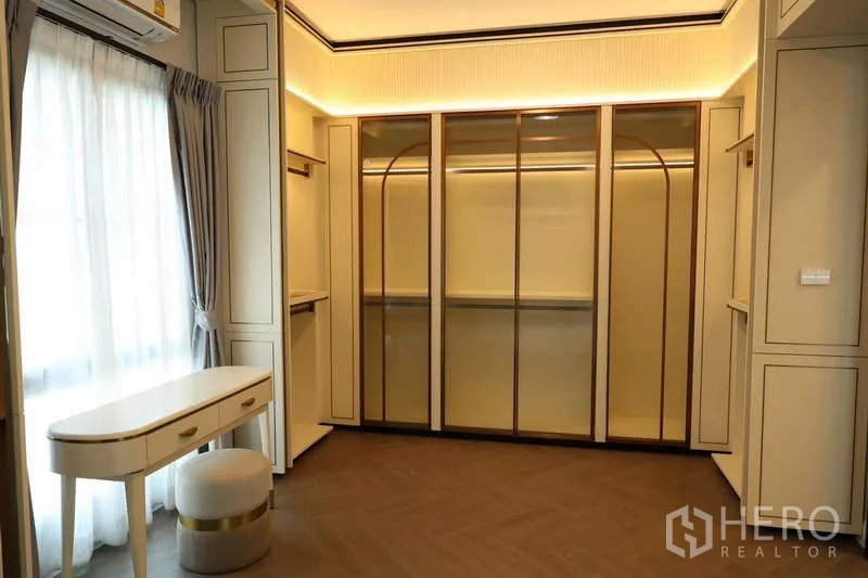 Detached House for rent or sale in Saphan Sung, Bangkok - Custom walk-in closet with glass-front wardrobes and vanity table.