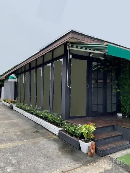 Retail Space for rent in Watthana, Bangkok - Streetfront single‑storey shop with glass facade, striped awning and small deck with planters.