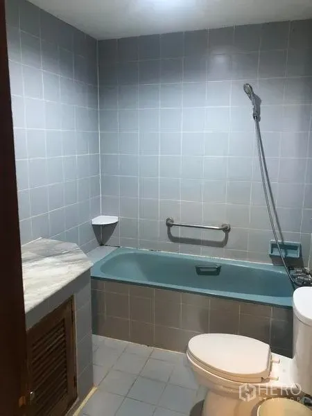 Retail Space for rent in Khlong Toei, Bangkok - Bathroom with gray tiles, bathtub, handheld shower and toilet.