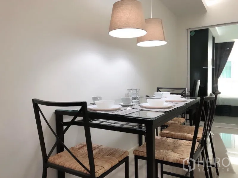 Condominium for rent or sale in Khlong Toei, Bangkok - Modern dining area with a glass-top table for four under warm pendant lights beside a sliding door.