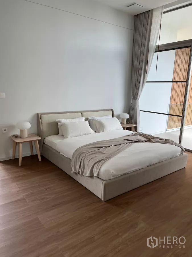 Detached House for rent in Saphan Sung, Bangkok - Spacious bedroom with upholstered bed, bedside tables and access to a balcony.