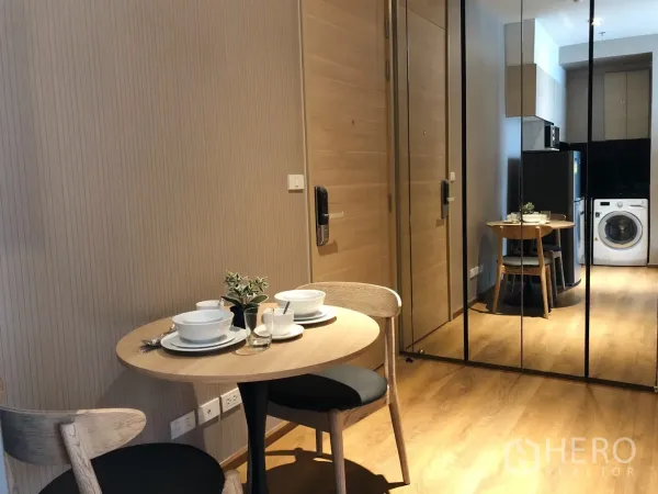 Condominium for rent in Khlong Toei, Bangkok - Dining nook for two with round table and mirrored wall facing the entry and kitchen.