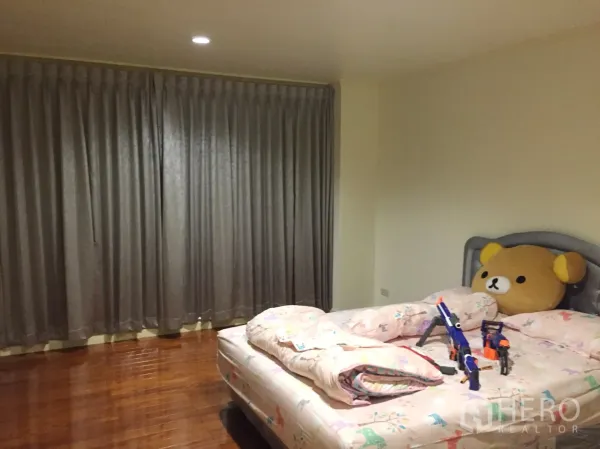 公寓 出租在Watthana, Bangkok - 温馨卧室，抛光木地板、灰色遮光窗帘与大床。