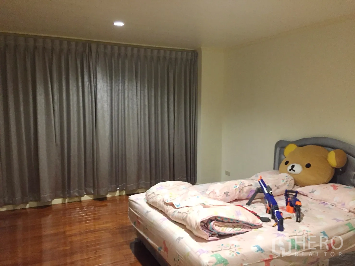 公寓 出租在Watthana, Bangkok - 温馨卧室，抛光木地板、灰色遮光窗帘与大床。