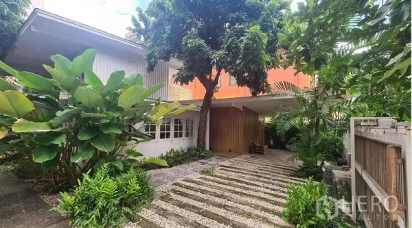 Detached House for rent in Watthana, Bangkok - Front garden and driveway view with mature trees.