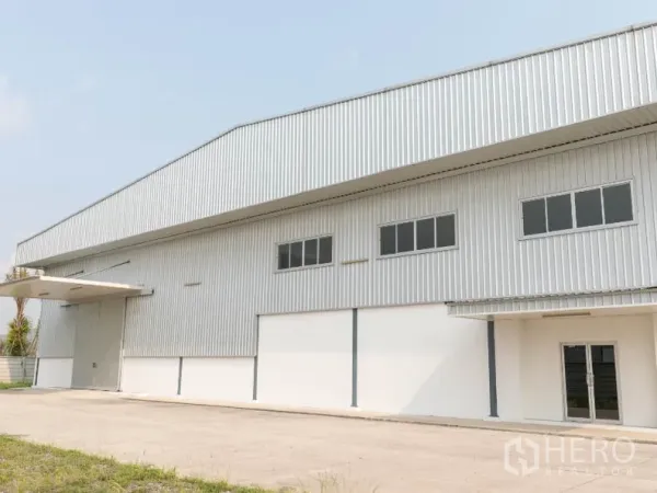 工厂 出租在Si Racha, Chon Buri - 厂房正立面，带装卸雨棚与卷帘大门