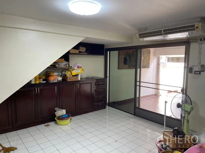 Home Office for rent in Watthana, Bangkok - Ground-floor multipurpose room with under-stair cabinetry and sliding glass door.