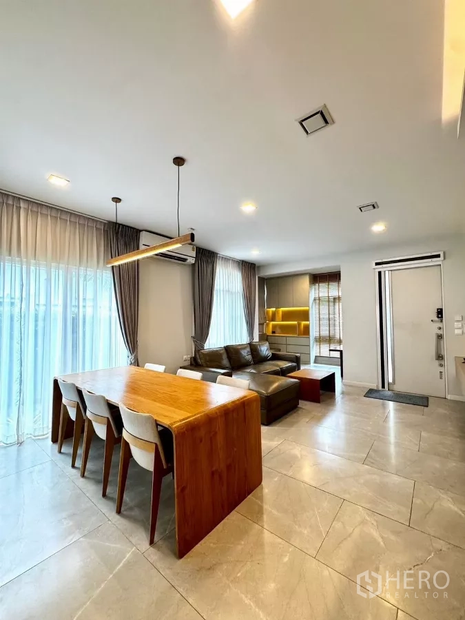 Detached House for rent in Prawet, Bangkok - Spacious open living–dining zone with tiled floors and full-height curtains.