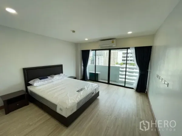 公寓 出租或出售在Watthana, Bangkok - 宽敞卧室，铺木地板，配大床与落地移门，通往可观赏曼谷天际线的阳台。