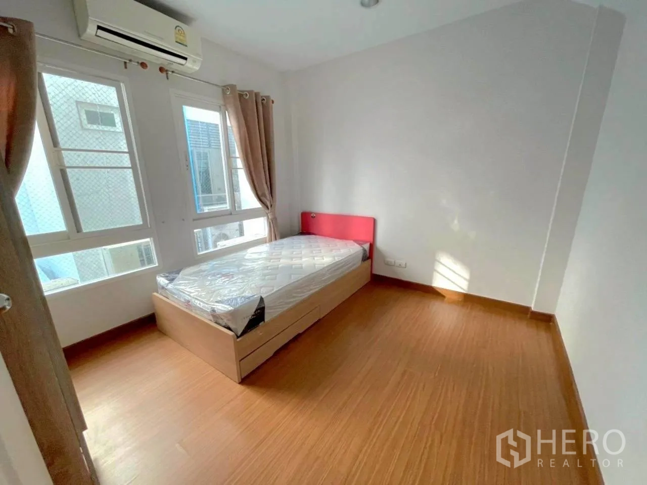 Townhouse for rent in Bang Kho Laem, Bangkok - Bright bedroom with single bed, wood flooring, air conditioner and curtained windows.