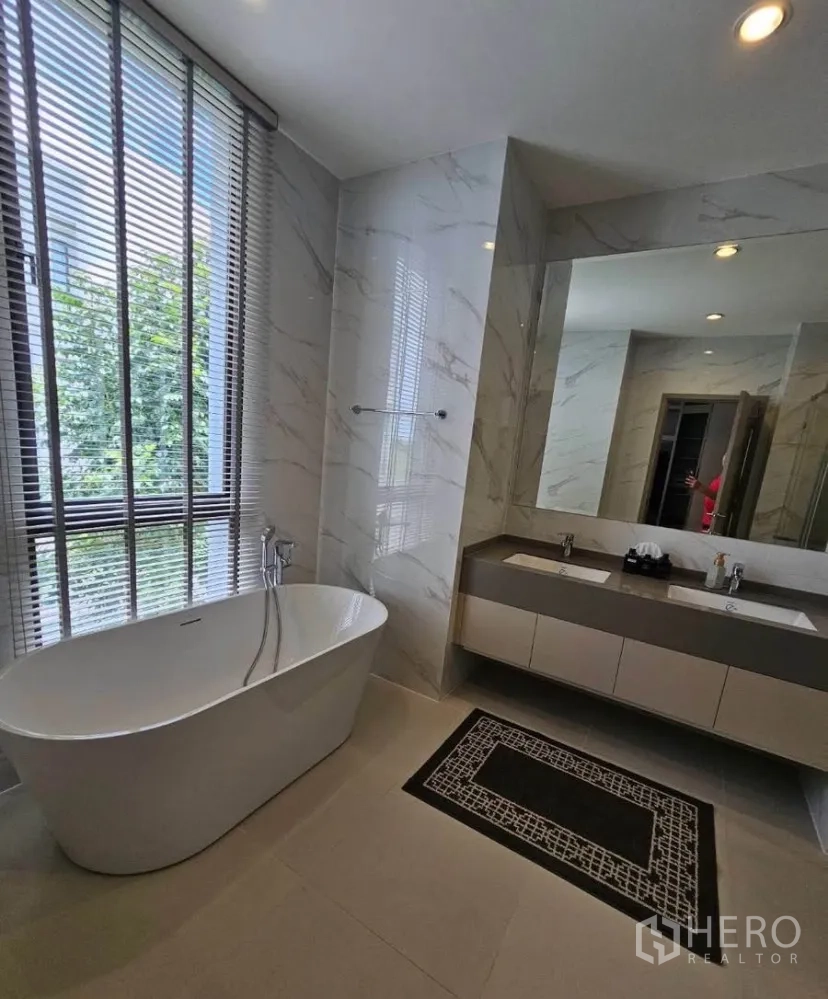 Detached House for rent or sale in Lat Krabang, Bangkok - Luxury bathroom with freestanding bathtub beside tall window and double‑sink vanity