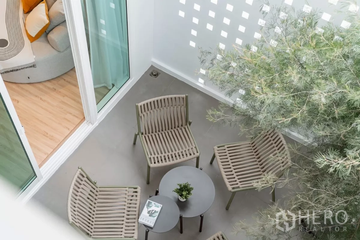 Detached House for rent in Saphan Sung, Bangkok - Private courtyard patio with outdoor chairs and nesting coffee tables under greenery.