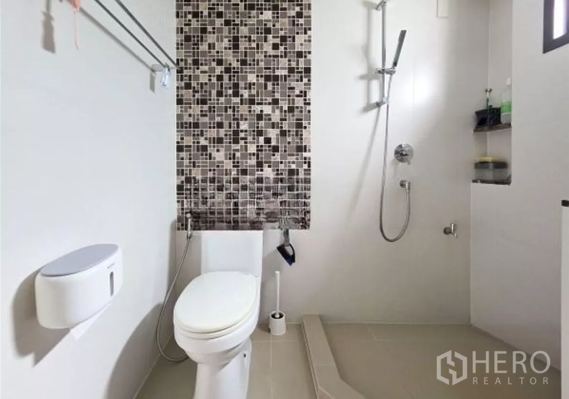 Detached House for sale in Bang Kapi, Bangkok - Bathroom with mosaic accent wall, toilet and walk-in shower area.