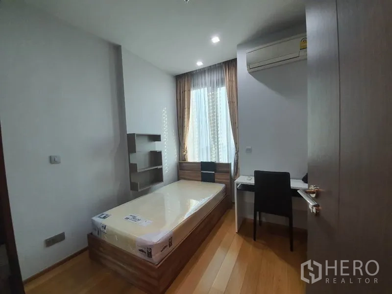 公寓 出租或出售在Khlong Toei, Bangkok - 次卧配单人床、书桌与空调，采光良好。