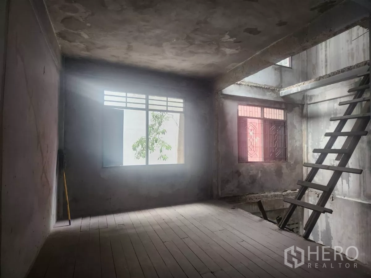 Shophouse for rent in Watthana, Bangkok - Loft-style corner with windows and ladder, showing a double-height volume.