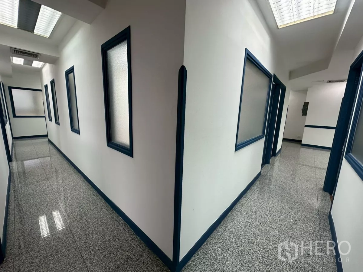 Office Space for rent in Khlong Toei, Bangkok - Clean corridor with granite floors and frosted interior windows.