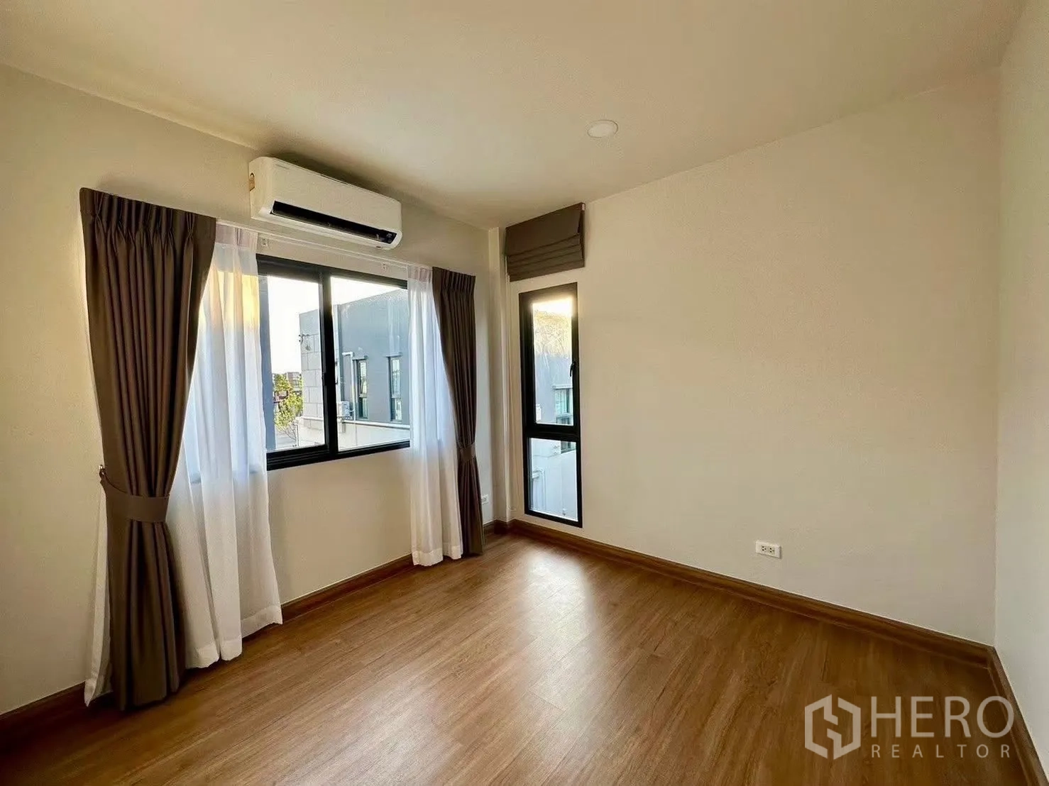 Detached House for rent in Bang Phli, Samut Prakan - Bright bedroom with wood flooring, corner windows and air conditioning.