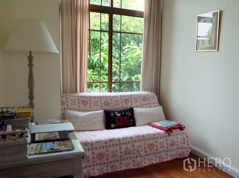 บ้าน ให้เช่าในWatthana, Bangkok - มุมอ่านหนังสืออบอุ่น โซฟาลายผ้า ใกล้หน้าต่างสูงมองเห็นต้นไม้