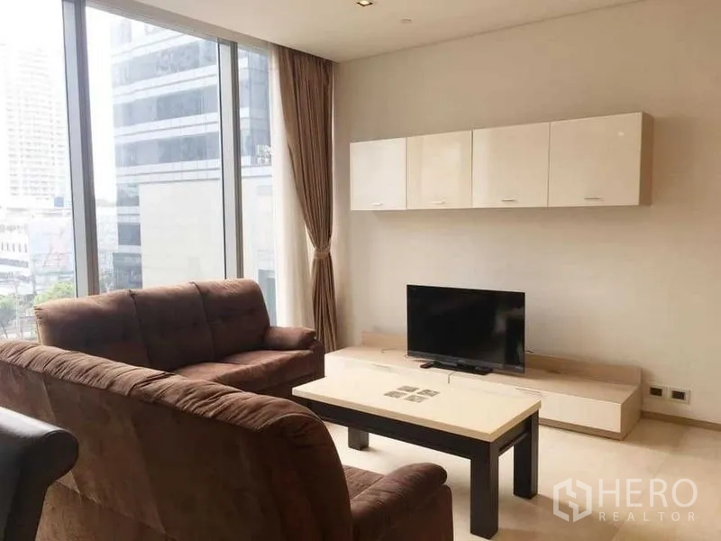 公寓 出租在Bang Rak, Bangkok - 明亮客厅，电视柜与壁柜，落地窗配窗帘。