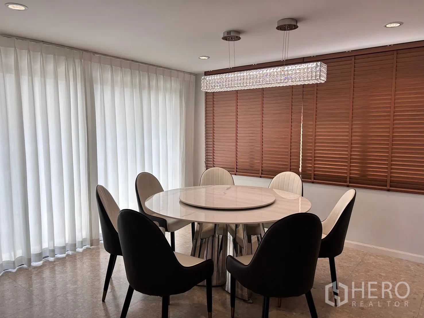 Detached House for rent in Lat Krabang, Bangkok - Dining room with round marble table, six modern chairs and crystal linear chandelier.