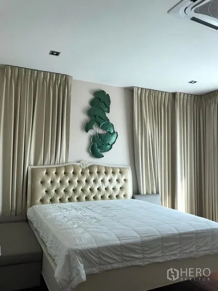 Detached House for sale in Saphan Sung, Bangkok - Primary bedroom with tufted headboard, full-height curtains and soft lighting.