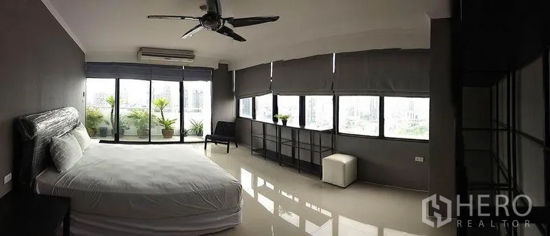 公寓 出租在Watthana, Bangkok - 主卧全景，整排窗户享城市景观，光亮地砖与吊扇