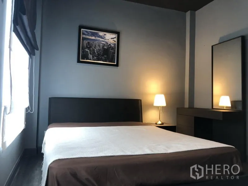 Townhouse for rent in Bang Kapi, Bangkok - Cozy third bedroom with bed, vanity, lamps and a window with blinds.