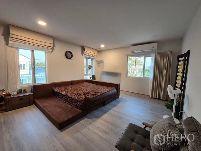 Detached House for rent in Bang Phli, Samut Prakan - Spacious master bedroom with platform bed, multiple windows and wood floors.