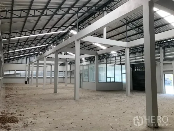 Factory for rent in Bang Bua Thong, Nonthaburi - Angled view of open production floor with skylights and a glass office room.