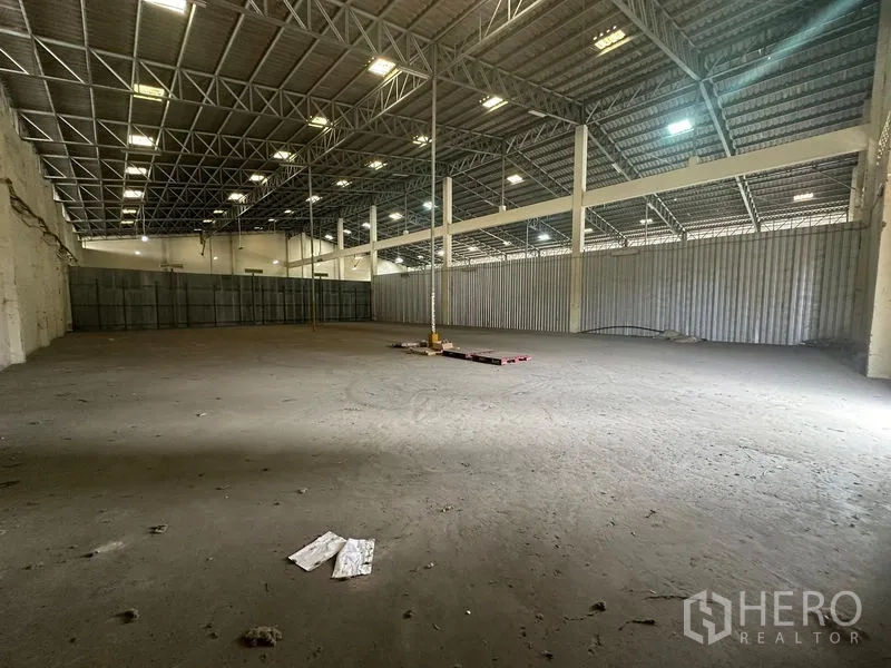Warehouse for rent in Yan Nawa, Bangkok - Open-plan storage hall with metal side panels, support columns and a wide clear span.
