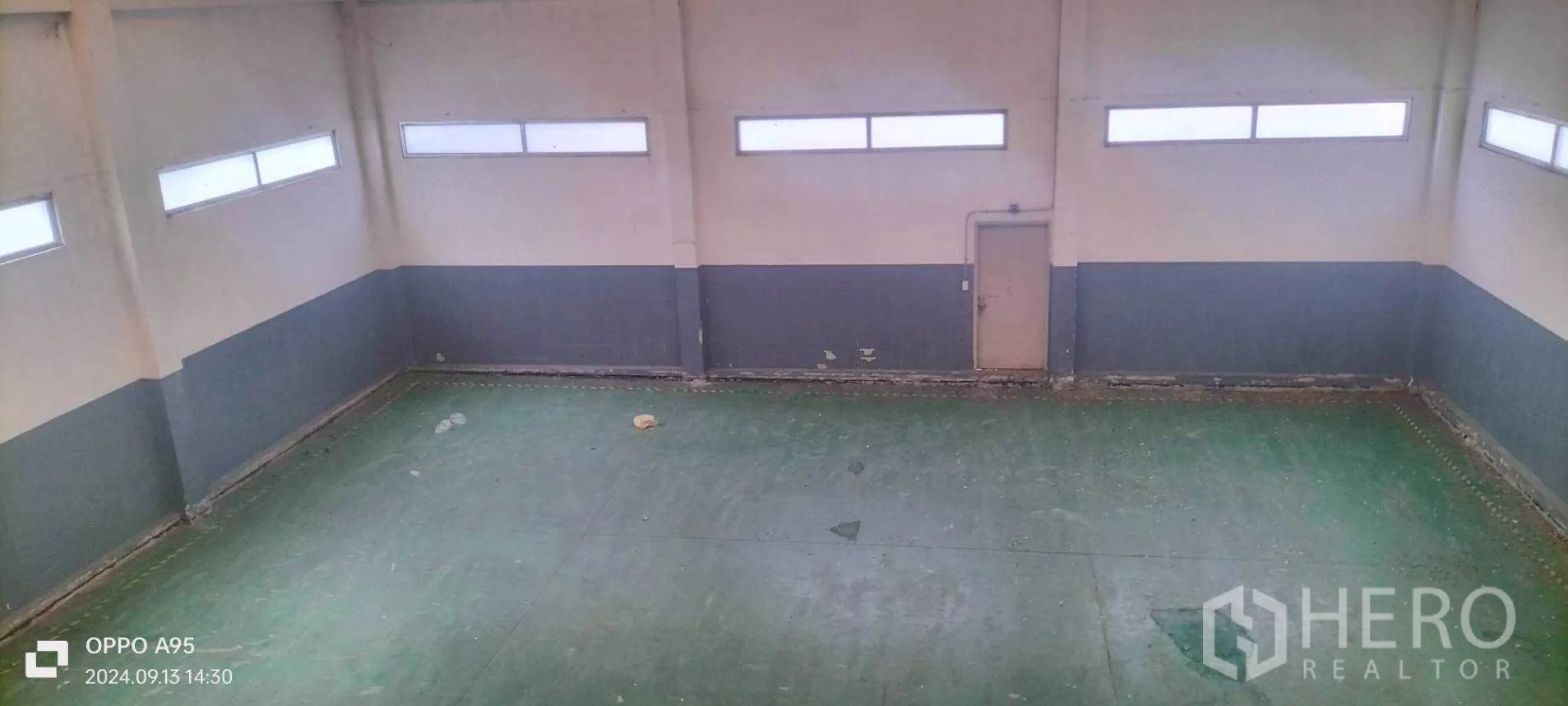 Factory for rent in Khlong Luang, Pathum Thani - Elevated view of warehouse with green epoxy floor and slim clerestory windows.