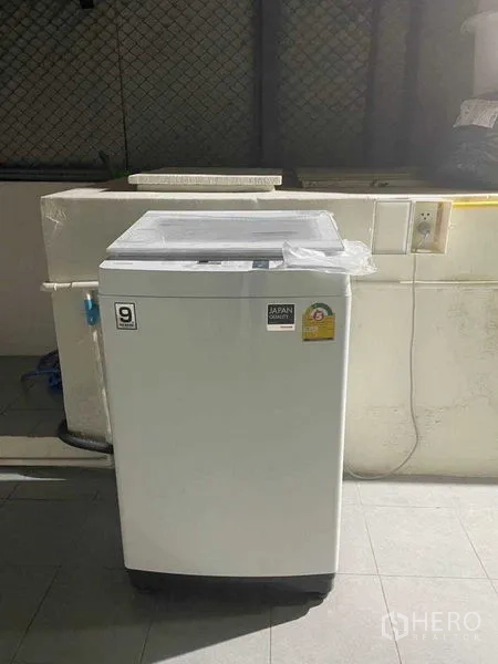 带办公室的家 出租或出售在Watthana, Bangkok - 顶开式洗衣机位于瓷砖工作阳台，带电源与水槽。