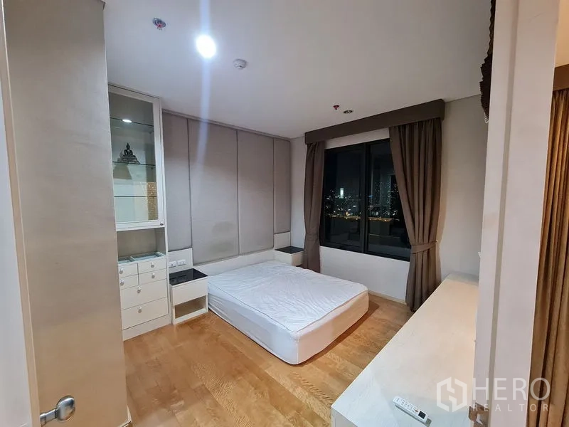 公寓 出售在Ratchathewi, Bangkok - 宽敞卧室，内置收纳与窗外夜色天际线