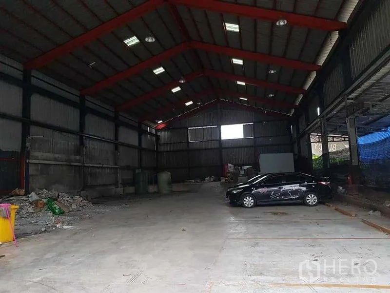 货栈 出租在Thung Khru, Bangkok - 大跨仓库地面平整，停放轿车，四周为波纹金属墙。