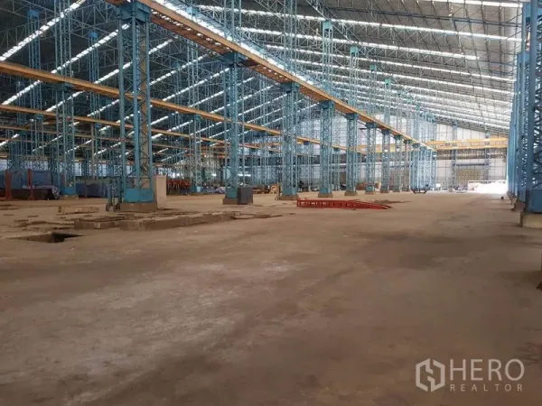 工厂 出租在Mueang Samut Sakhon, Samut Sakhon - 工厂内部高挑钢结构大厅，蓝色立柱、天窗与天车梁，空间开阔。