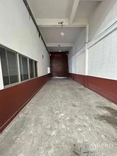 Warehouse for rent in Bang Phli, Samut Prakan - Covered loading bay corridor with concrete floor and roller shutter door