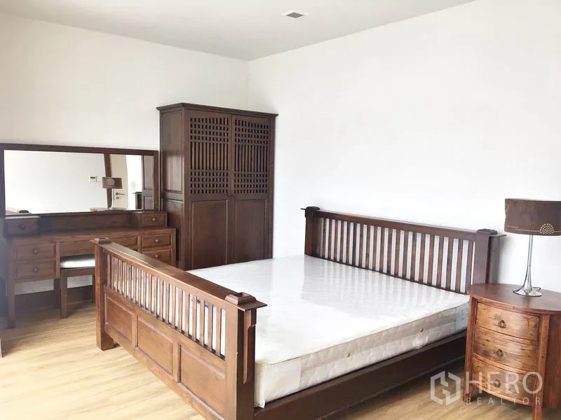 公寓 出租在Khlong Toei, Bangkok - 主卧配木床、衣柜和梳妆台。