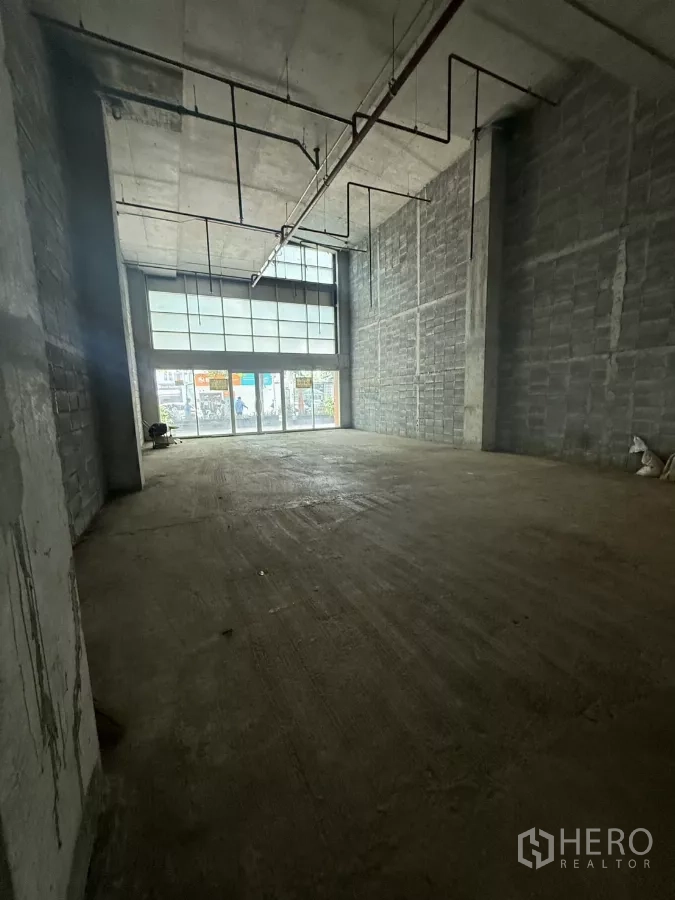 零售空间 出租在Bang Rak, Bangkok - 宽敞混凝土地面高挑商铺，砌块墙体，整面落地玻璃入口，适合自定义装修。