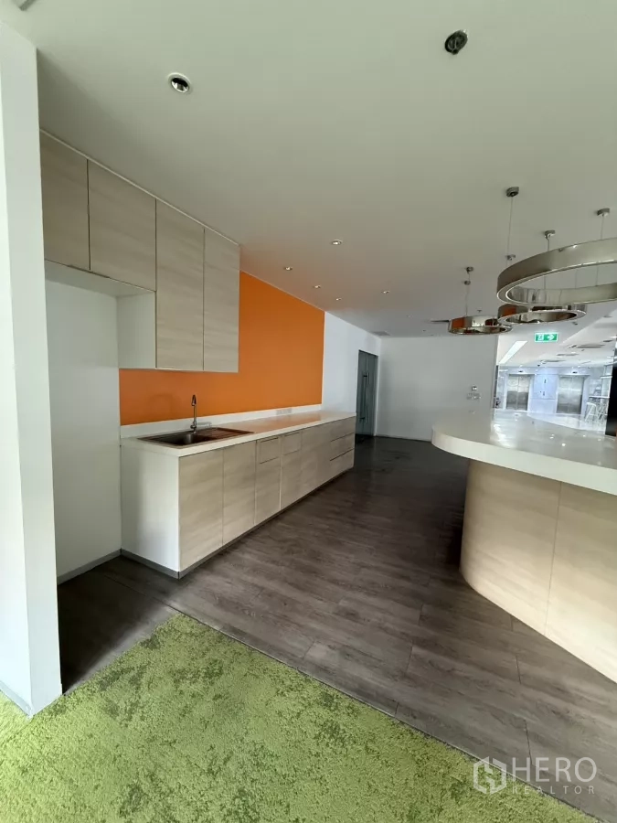 Retail Space for rent in Bang Rak, Bangkok - Built-in pantry with sink, light wood cabinetry and circular pendant lights beside a curved counter.