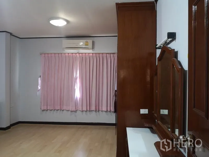 Detached House for sale - Bedroom with pink curtains, air conditioning and a wooden vanity.