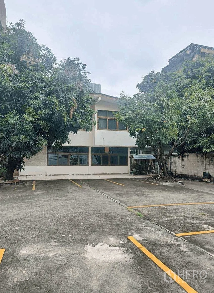 家庭办公室 for rent in Bang Rak, Bangkok - 两层建筑外观，树荫停车位清晰划线