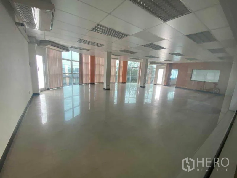 货栈 出租在Pathum Thani - 开放式办公空间，立柱、百叶窗与日光灯照明