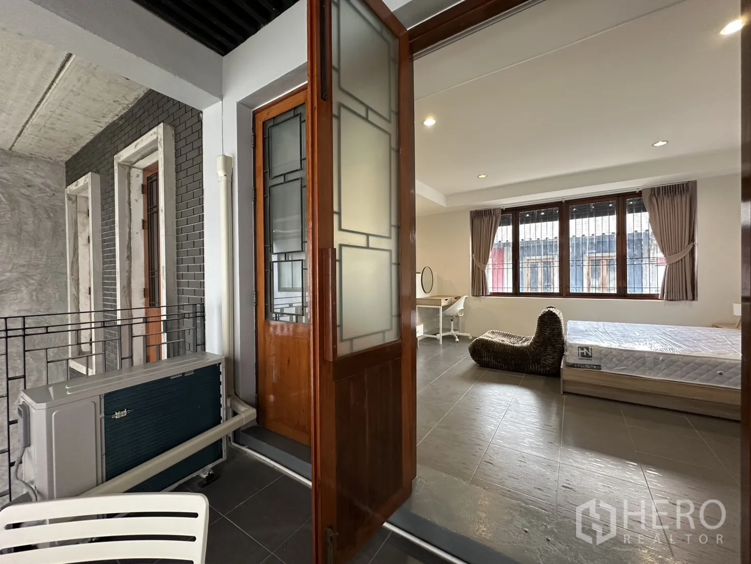 公寓 for rent in Pathum Wan, Bangkok - 卧室配书桌并通向带顶露台，露台设圆桌。