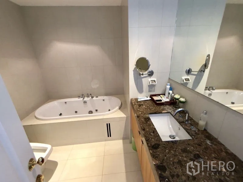Condominium for rent in Pathum Wan, Bangkok - Bathroom with marble‑style vanity, under‑mount sink and built‑in bathtub.