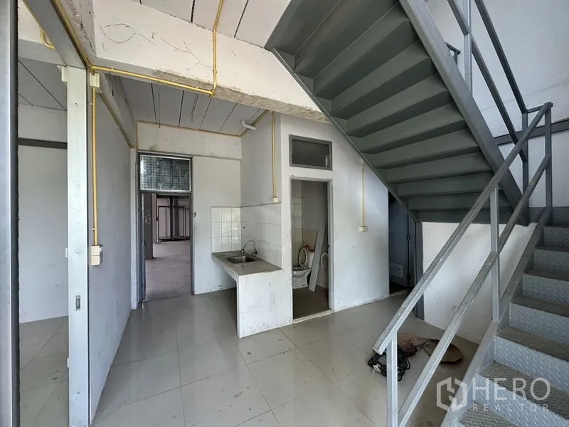 Factory for rent in Lam Luk Ka, Pathum Thani - Ground-floor utility area featuring a sink, restroom, and metal staircase.